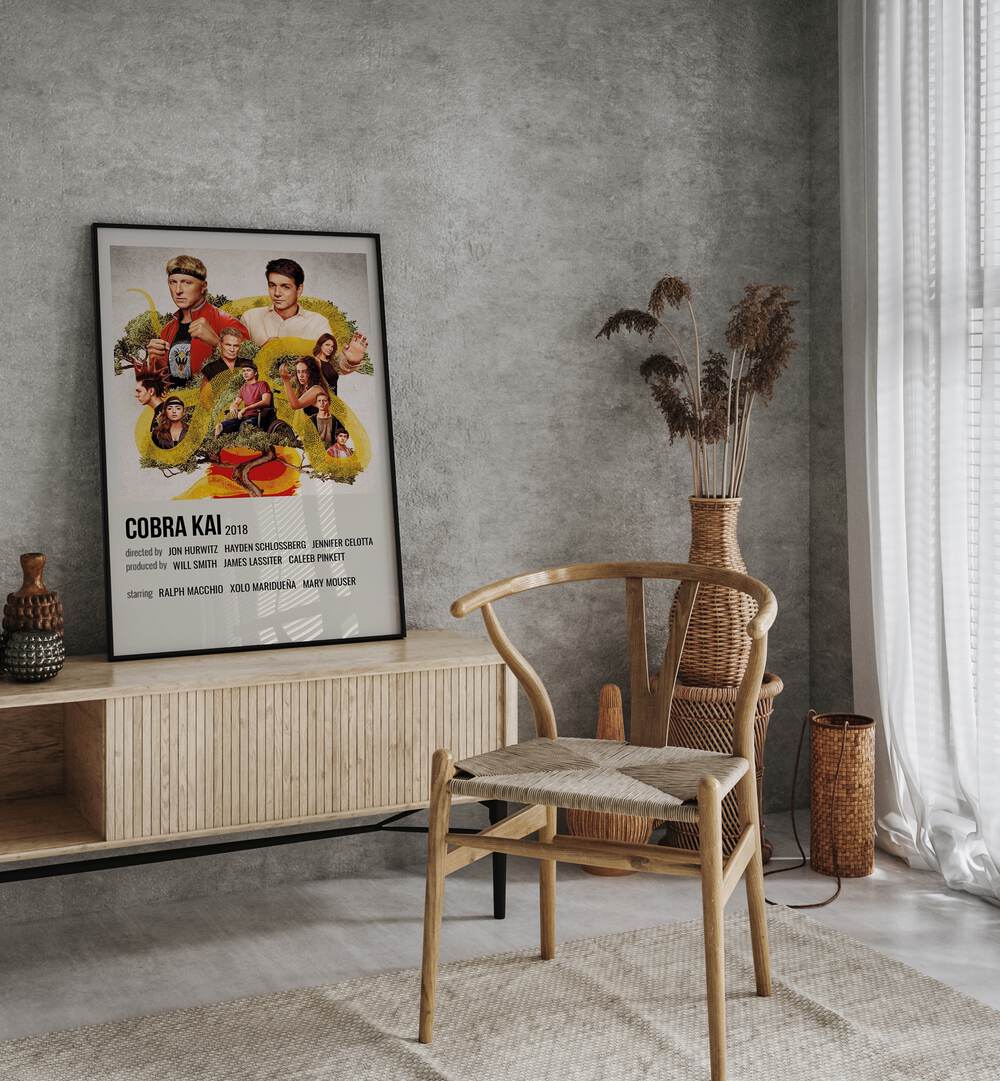 Cobra Kai 2018 Movie Posters in Black Plain Frame placed on a table beside oakwood chair