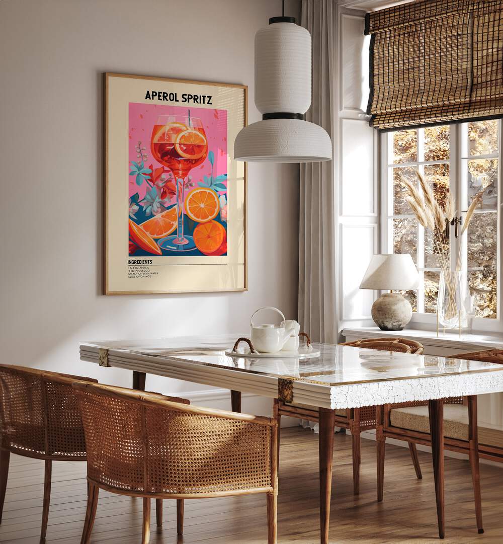 Colourful Aperol Spritz Cafe Art Prints Cafe Posters in Oak Wood Plain Frame placed on a wall in a dining room area beside a window and behind a dining table