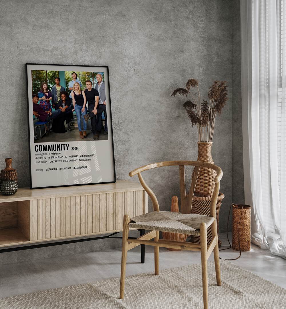 Community 2009 Movie Posters in Black Plain Frame placed on a table beside oakwood chair