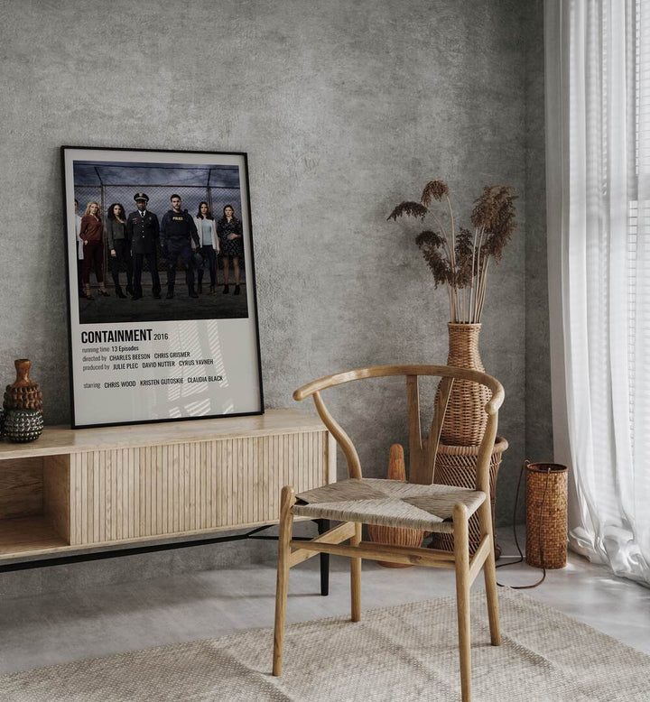 Containment 2016 Movie Posters in Black Plain Frame placed on a table beside oakwood chair