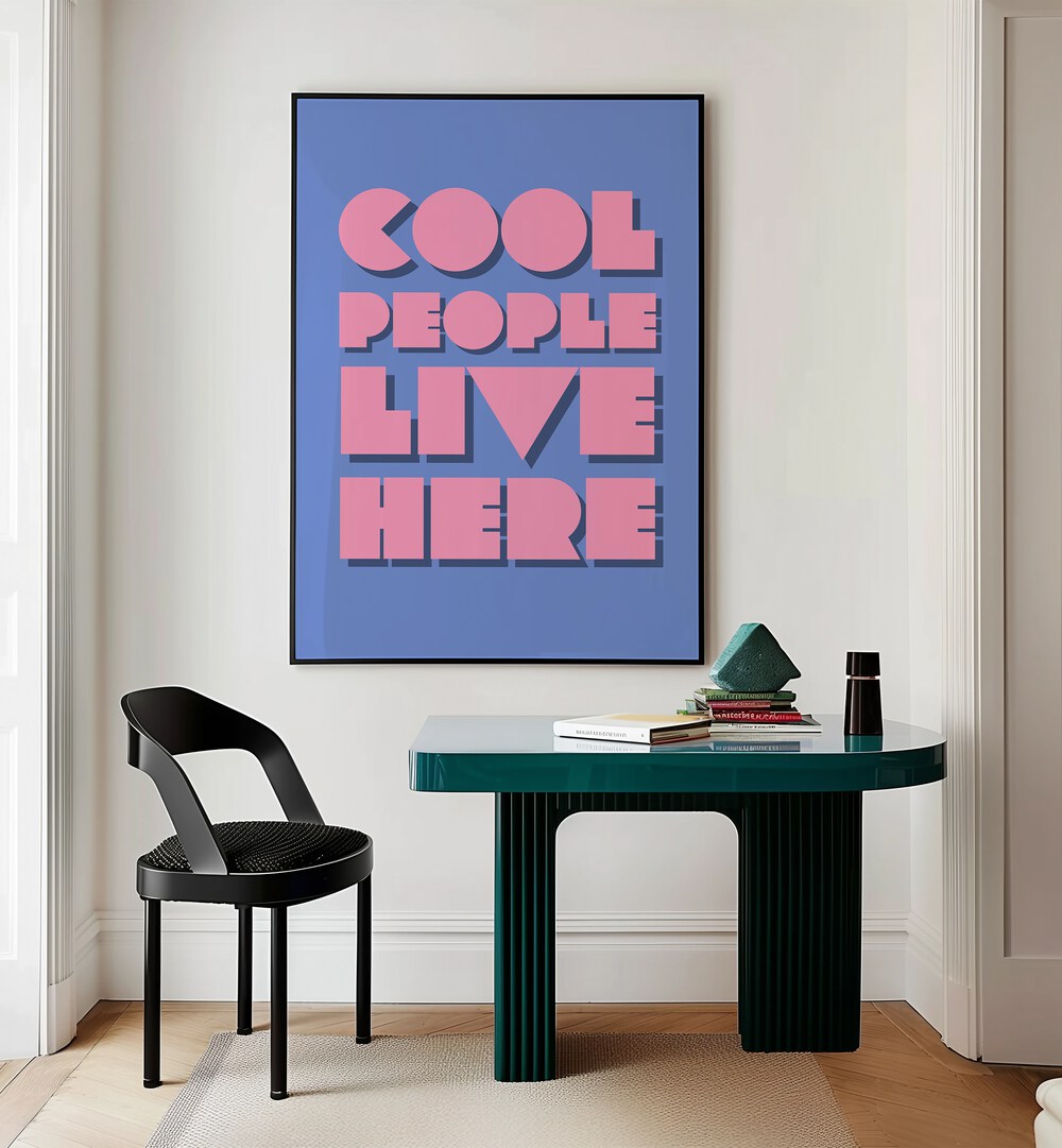 Cool People Live Here by Athene Fritsch Quotes and Typography Posters in Black Plain Frame placed on a wall behind a study table