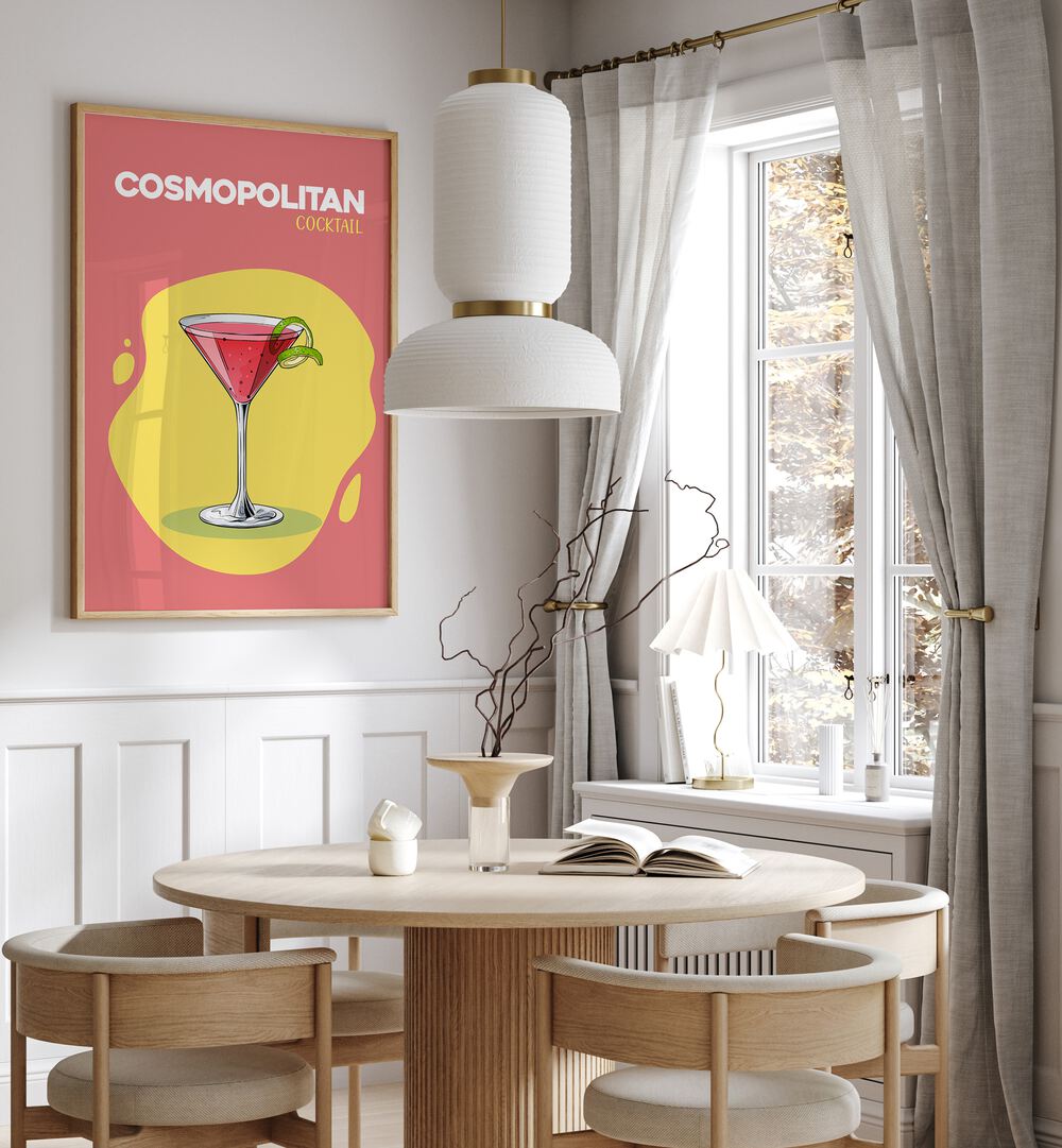 Cosmopolitan Cocktail I Cafe Art Prints Cafe Posters in Oak Wood Plain Frame placed on a wall in a dining room area beside a window and behind a dining table