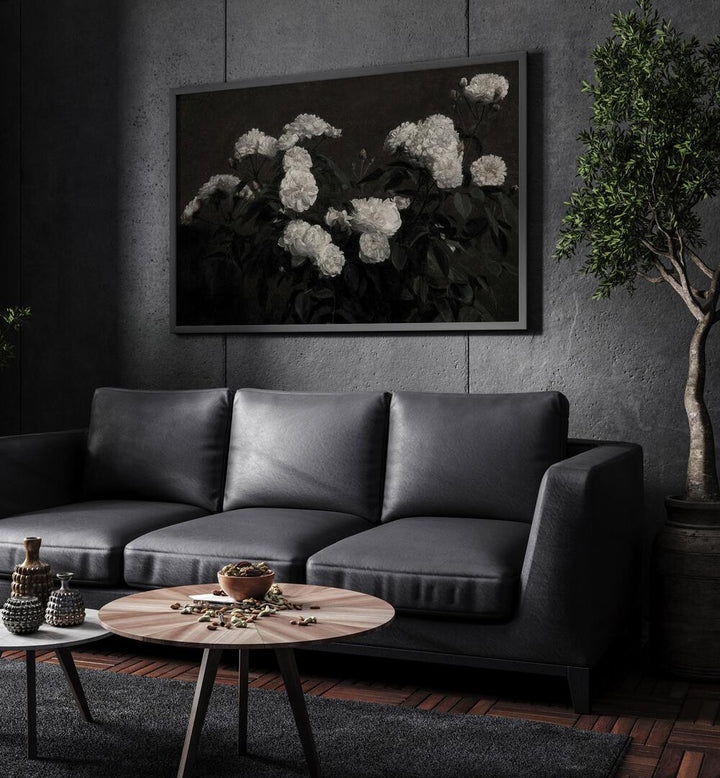 Cryptic Bloom Cradle Gothic Wall Art Prints in Black Plain Frame hanging on a wall above black leather couch beside a plant.