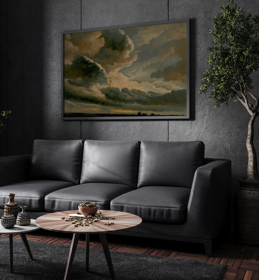 Darkened Heavens Gothic Wall Art Prints in Black Plain Frame hanging on a wall above black leather couch beside a plant.