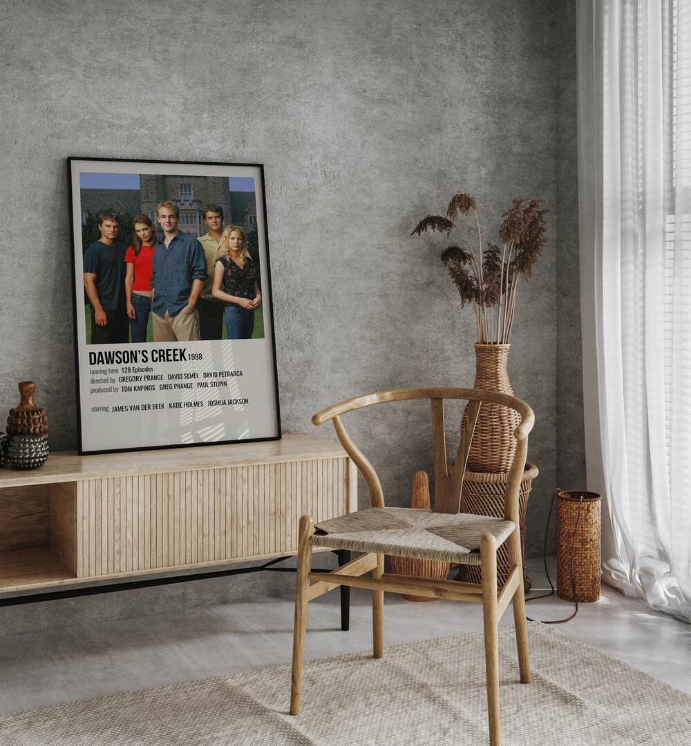 Dawsons Creek 1998 Movie Posters in Black Plain Frame placed on a table beside oakwood chair