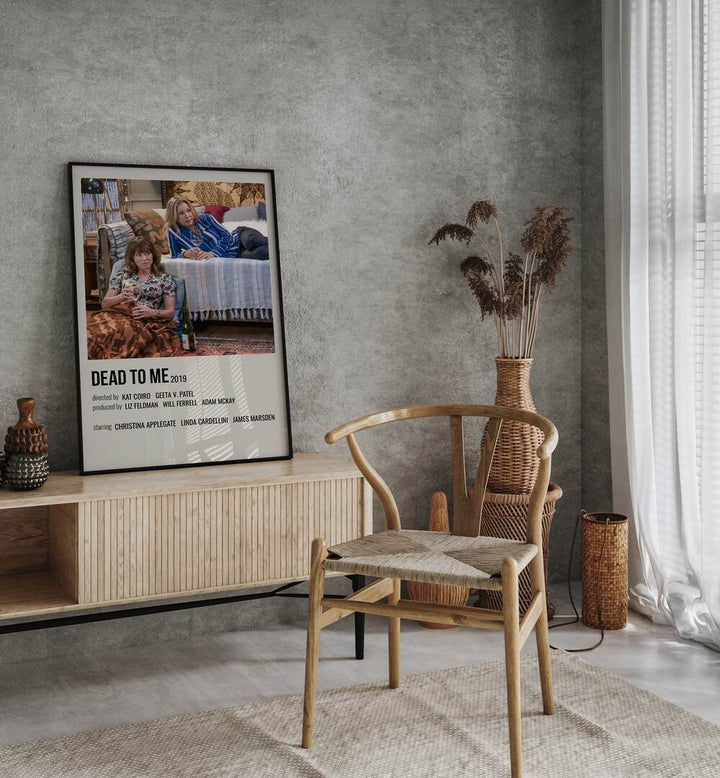 Dead To Me 2019 Movie Posters in Black Plain Frame placed on a table beside oakwood chair