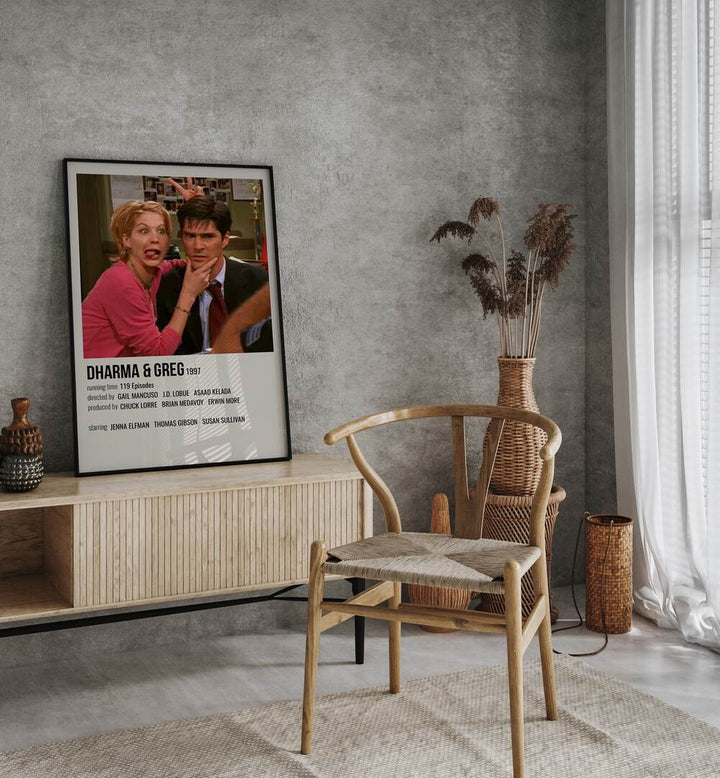 Dharma & Greg 1997 Movie Posters in Black Plain Frame placed on a table beside oakwood chair