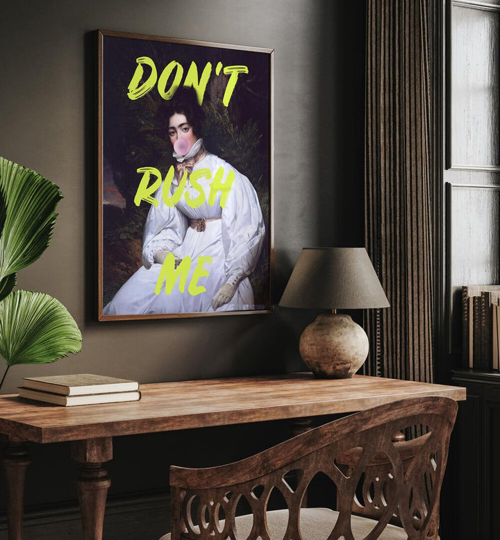 Dont Rush Me II by Grace Digital Art Co Altered Art Prints in Dark Wood Plain Frame placed on a wall behind a study table and beside an plant