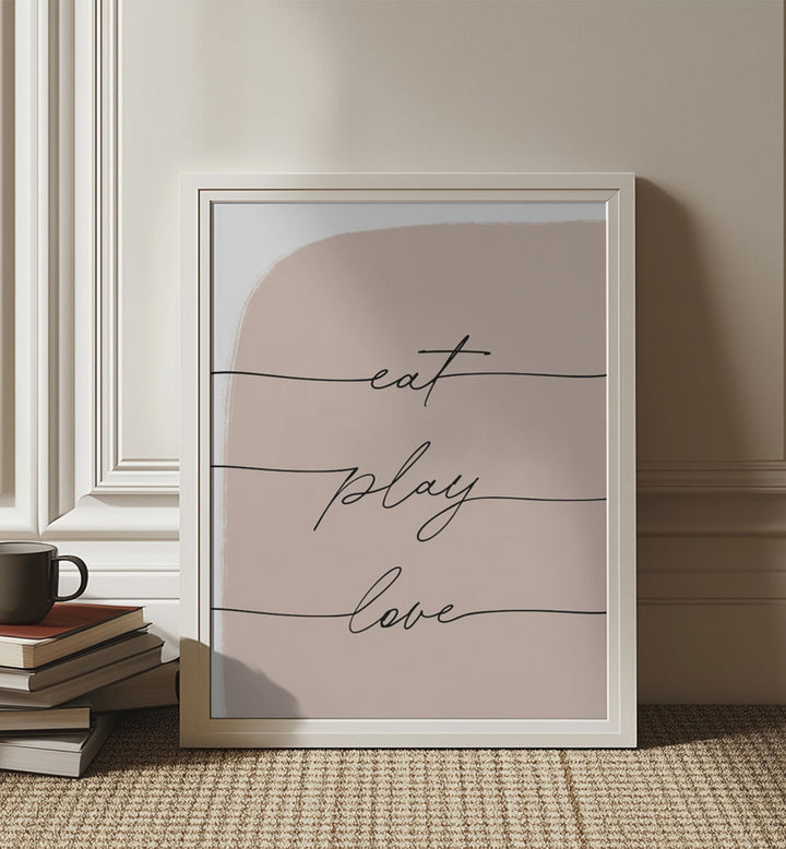 EAT PLAY LOVE , QUOTES typography poster, blush script framed leaning by books and mug