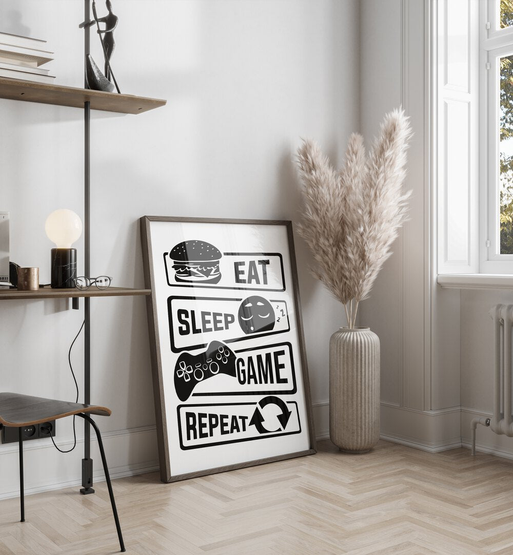 Eat Sleep Game Repeat III Gaming Art Painting Artwork in plain dark wood frame beside a flower vase 