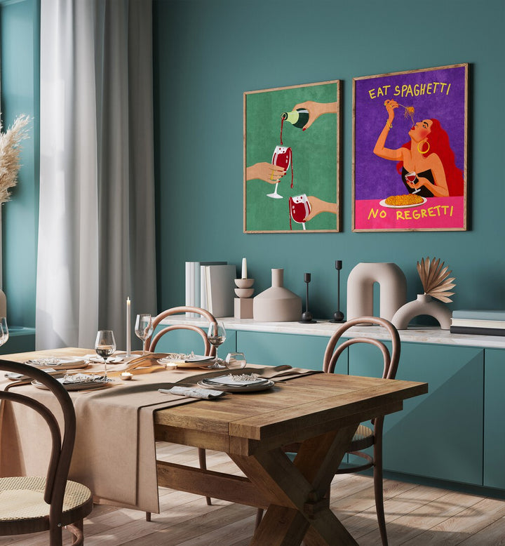 
"Modern dining room interior with a sleek black table, gray upholstered chairs, and a vibrant set of two framed wall art pieces. The artwork includes a green print of wine being poured and a colorful 'Eat Spaghetti No Regretti' illustration, adding bold personality and playful charm to the dark-toned space. Perfect for contemporary home decor inspiration."