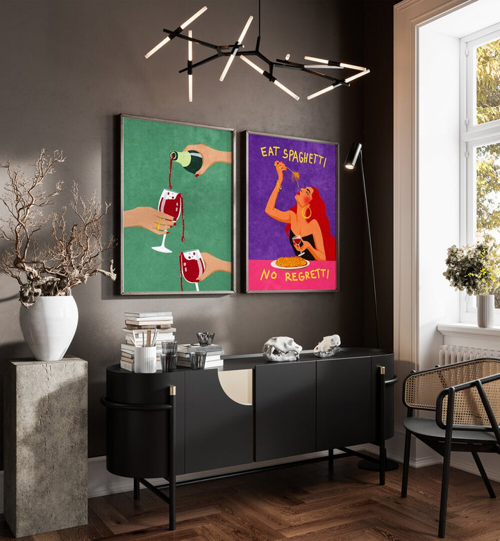 
"Modern dining room interior with a sleek black table, gray upholstered chairs, and a vibrant set of two framed wall art pieces. The artwork includes a green print of wine being poured and a colorful 'Eat Spaghetti No Regretti' illustration, adding bold personality and playful charm to the dark-toned space. Perfect for contemporary home decor inspiration."