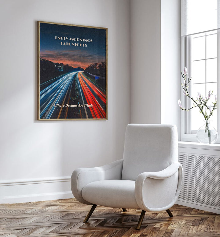 Early Mornings Late Nights II Quotes And Typography Posters in Oak Wood Plain Frame placed on a White Colored Wall near a White Sofa Chair in the Drawing Room