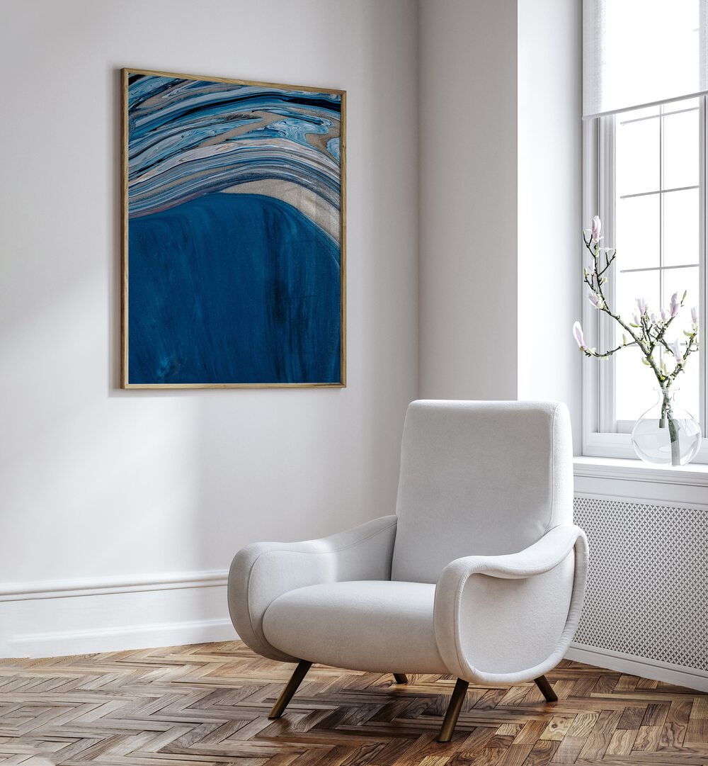 Ebb and Flow Beach Prints Coastal Wall Art in Oak Wood Plain Frame placed on a white wall beside a sofa