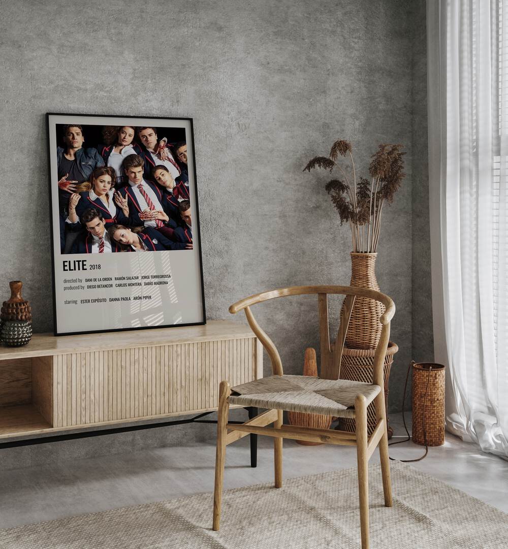 Elite 2018 Movie Posters in Black Plain Frame placed on a table beside oakwood chair