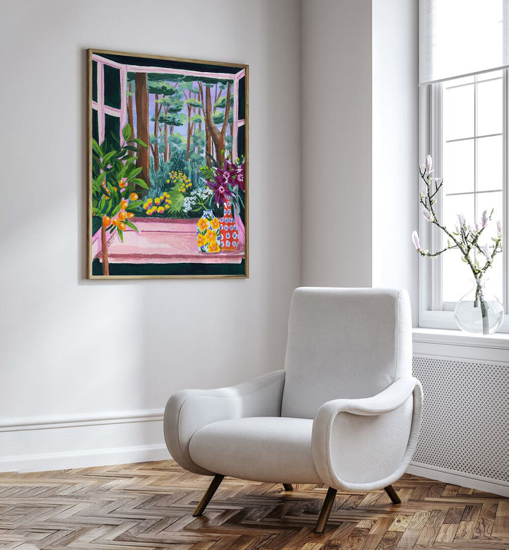 Enchanted Garden By Sarah Gesek Landscape Art Prints in Oak Wood Plain Frame placed on a white wall beside a chair and window