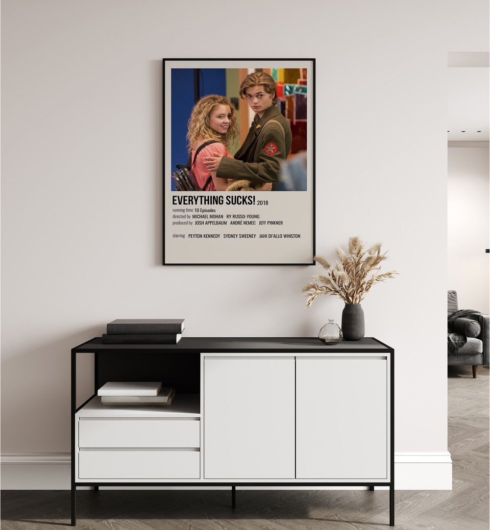 Everything Sucks 2018 I Movie Posters in Black Plain Frame placed on a white wall behind a black and white table