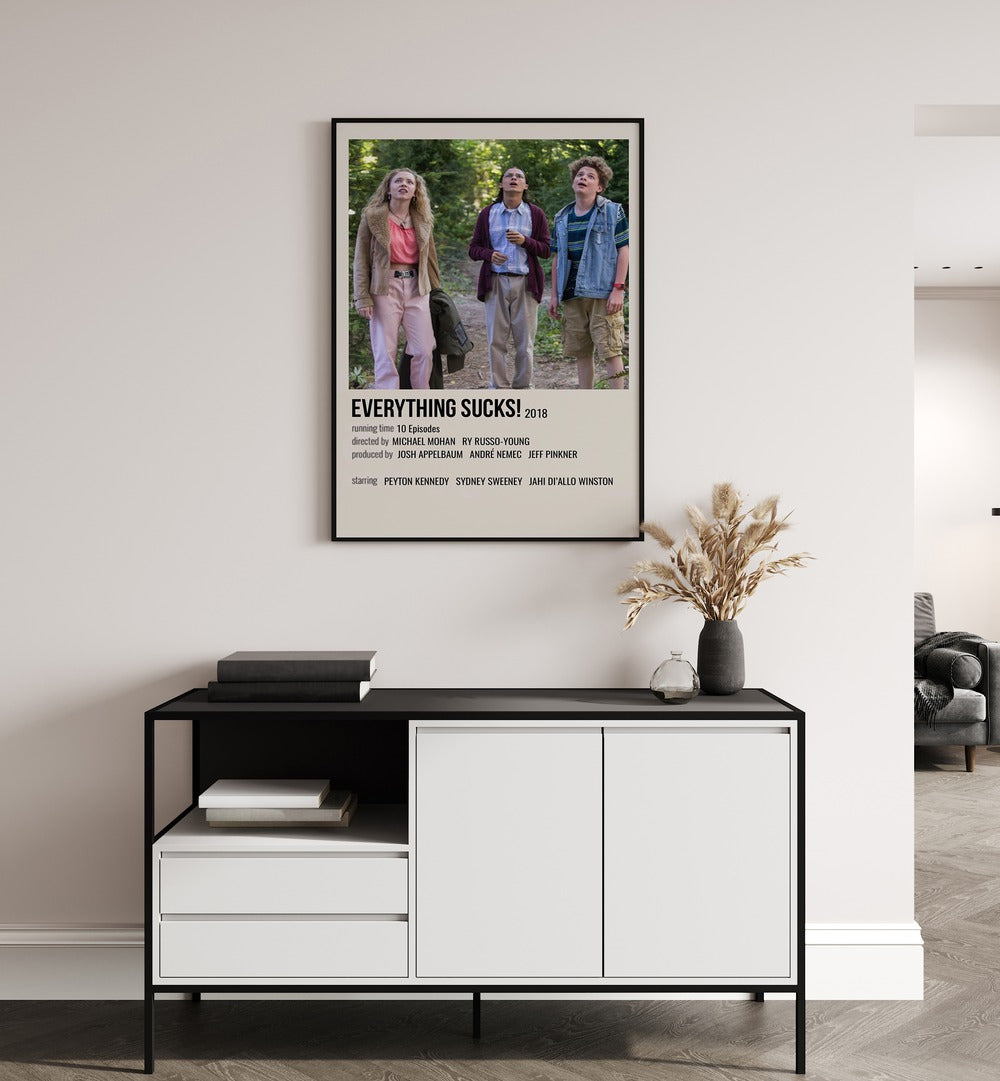Everything Sucks 2018 II Movie Posters in Black Plain Frame placed on a white wall behind a black and white table