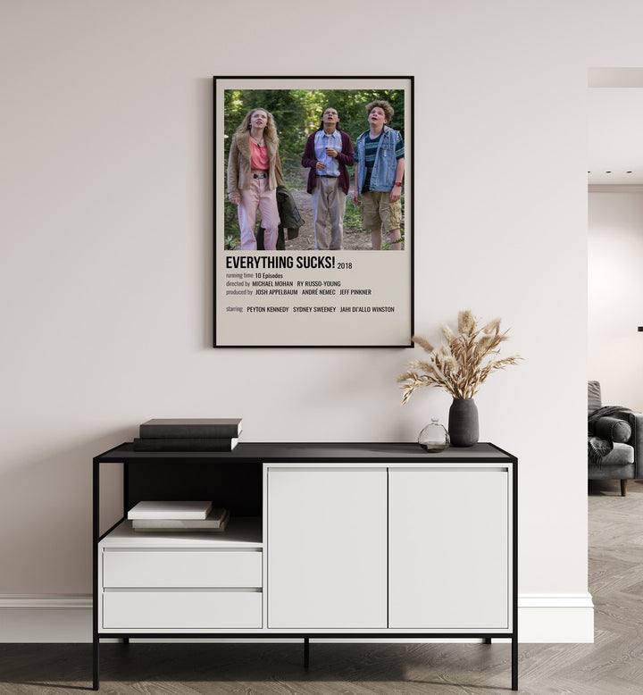 Everything Sucks 2018 II Movie Posters in Black Plain Frame placed on a white wall behind a black and white table