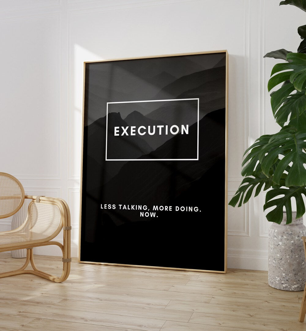 Execution Quotes And Typography Posters in Oak Wood Plain Frame placed on the floor near a White Colored Wall in the Drawing Room