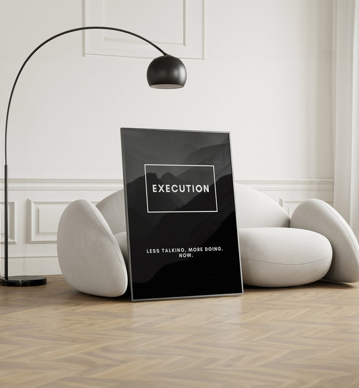 Execution Quotes And Typography Posters in Black Plain Frame placed on the floor near a White Sofa in the Living Room