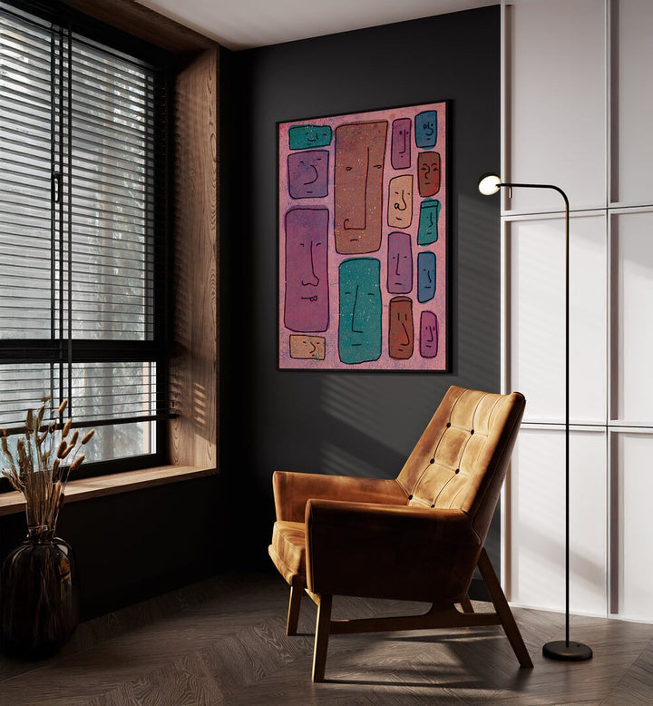 Faces Abstract Art Abstract Paintings in Black Plain Frame placed on a Dark Grey Colored Wall near a Brown Sofa Chair in the Drawing Room