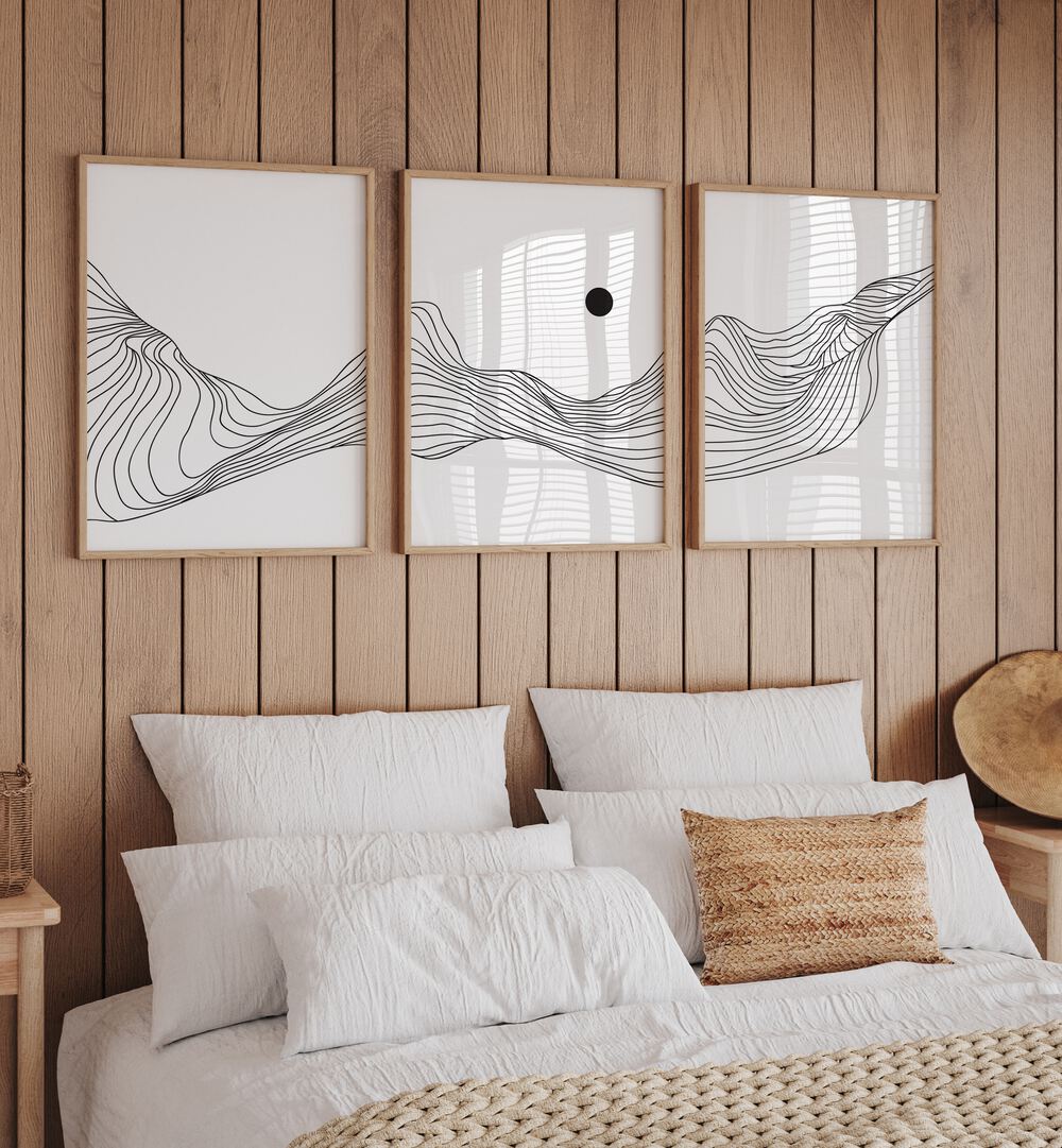 Fluidic Dunes Set Set Of 3 Paintings in Oak Wood Plain Frame placed on a bedroom wall behind a bed 