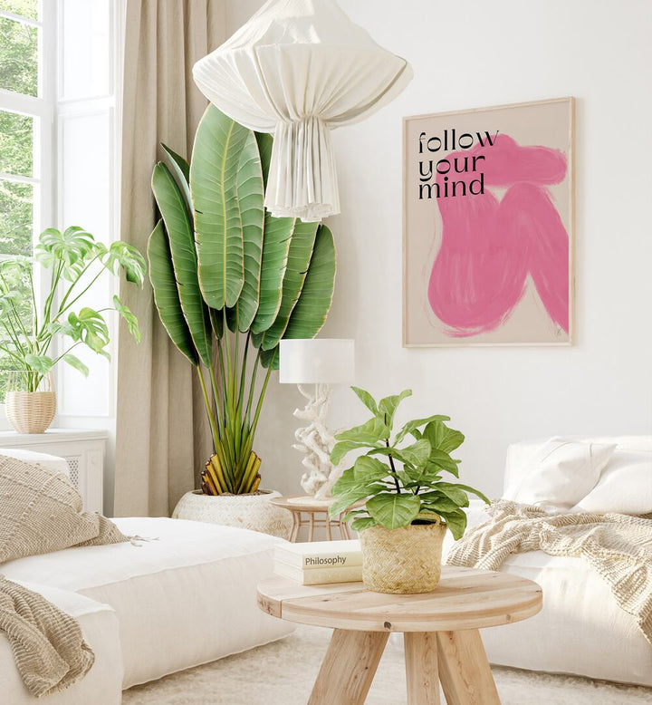 Follow Your Mind by Anne-marie Volfova Quotes and Typography Posters in Oak Wood Plain Frame placed on a wall in living room behind a sofa and beside a plant