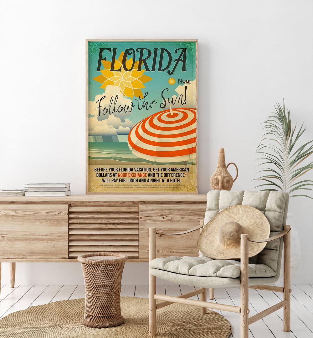 Follow the Sun  Retro Travel Posters in Oak Wood Plain Frame placed on a console table behind a chair