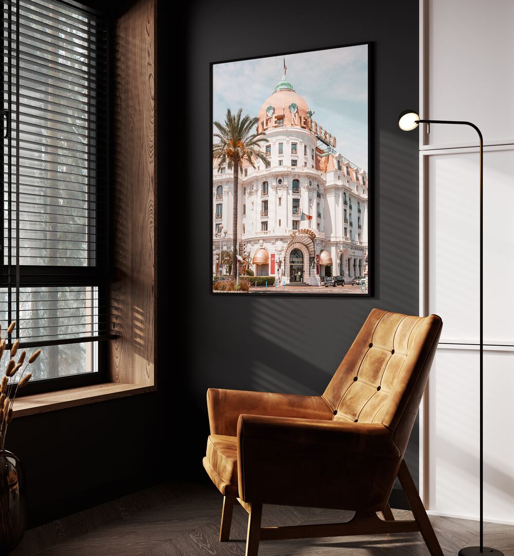 French Riviera Building By Grace Digital Art Co Beach Prints in Black Plain Frame placed on a wall beside a window and an orange sofa