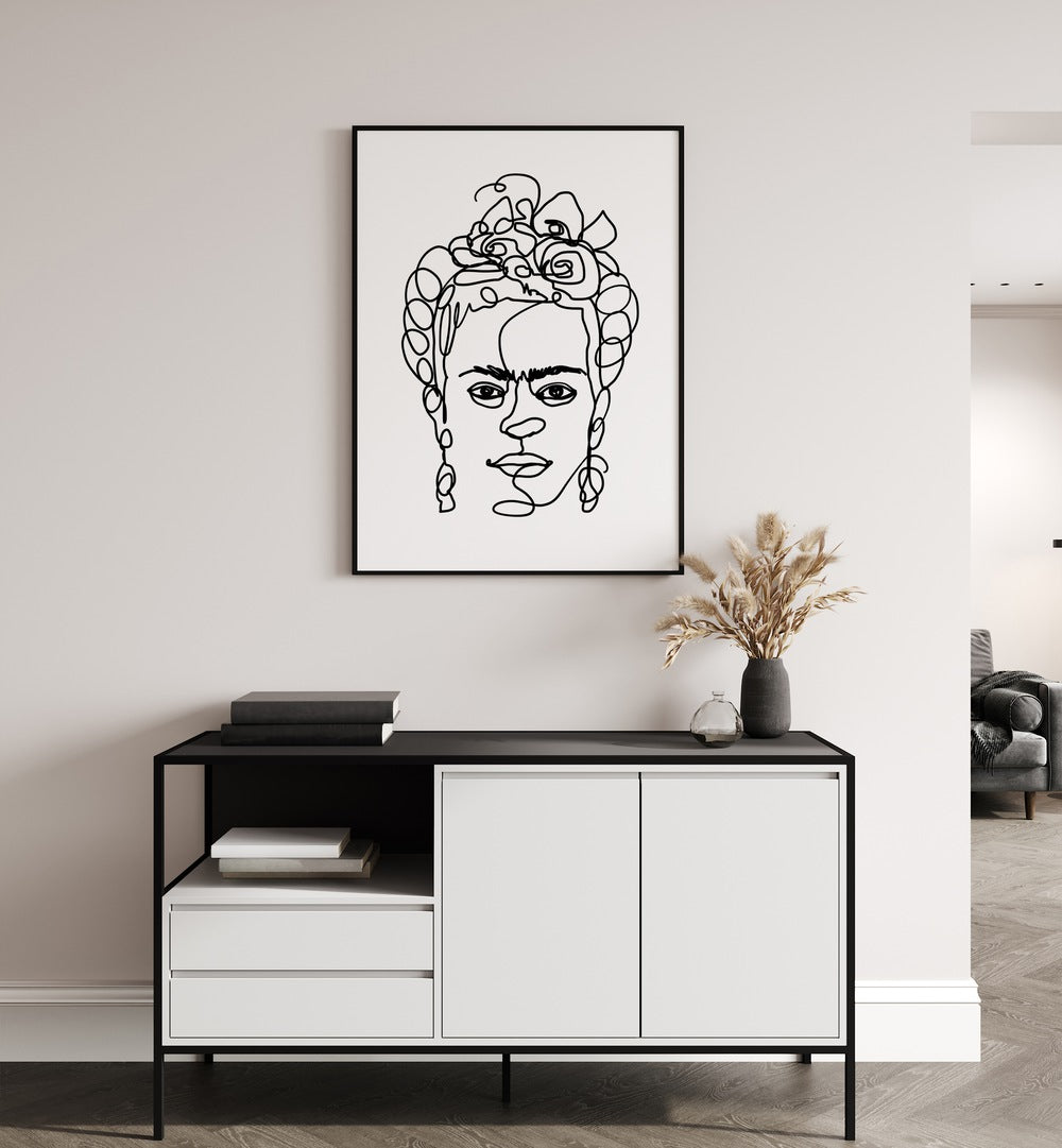 Frida Made Me by Hanna Lee Tidd Line Art Paintings Line Art Prints in Black Plain Frame placed on a wall behind a console table