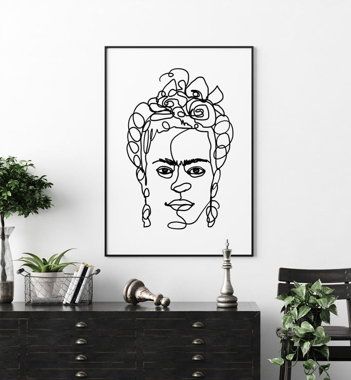 Frida Made Me by Hanna Lee Tidd Line Art Paintings Line Art Prints in Black Plain Frame placed on a wall behind a console table