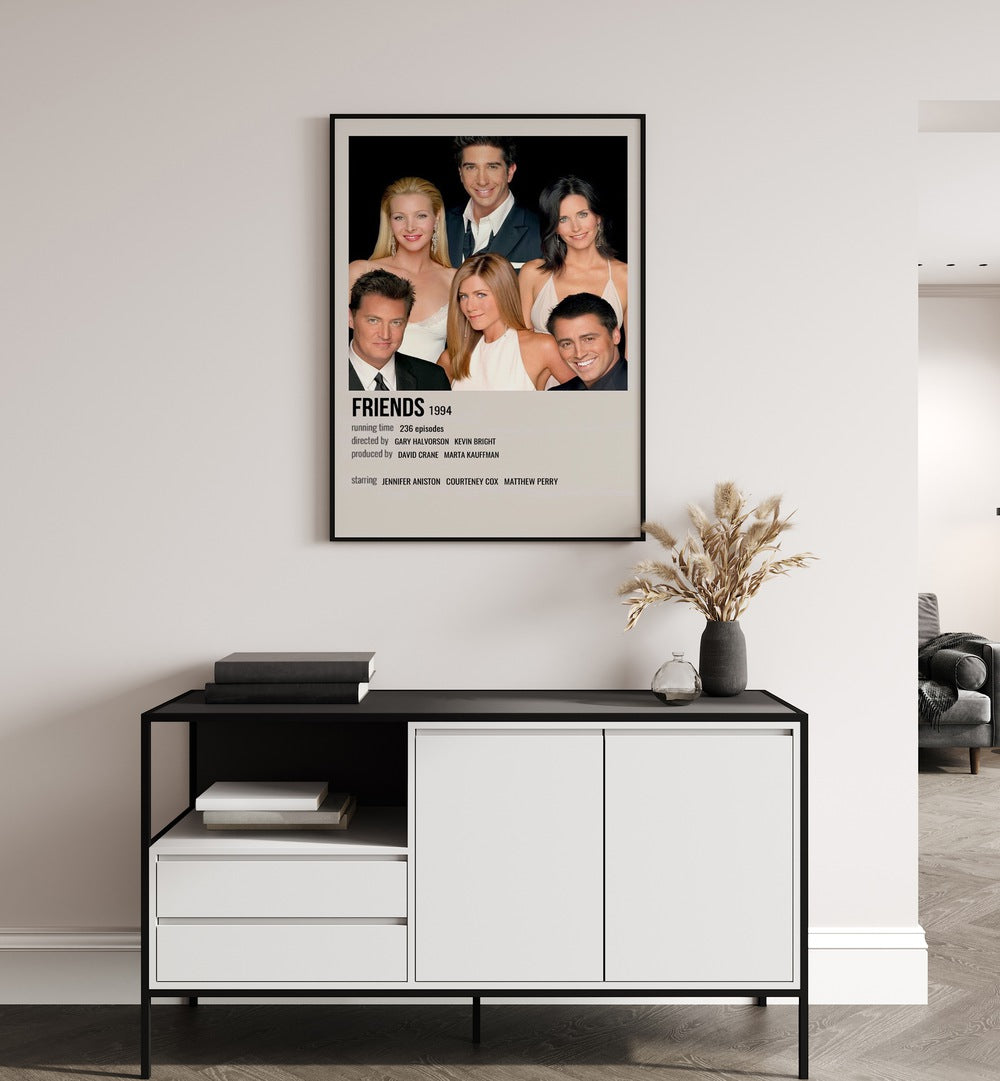 Friends 1994 I Movie Posters in Black Plain Frame placed on a white wall behind a black and white table