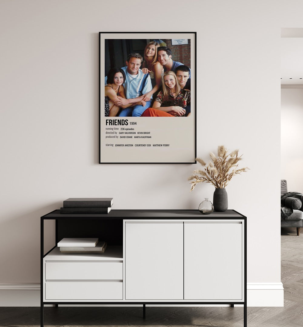 Friends 1994 II Movie Posters in Black Plain Frame placed on a white wall behind a black and white table