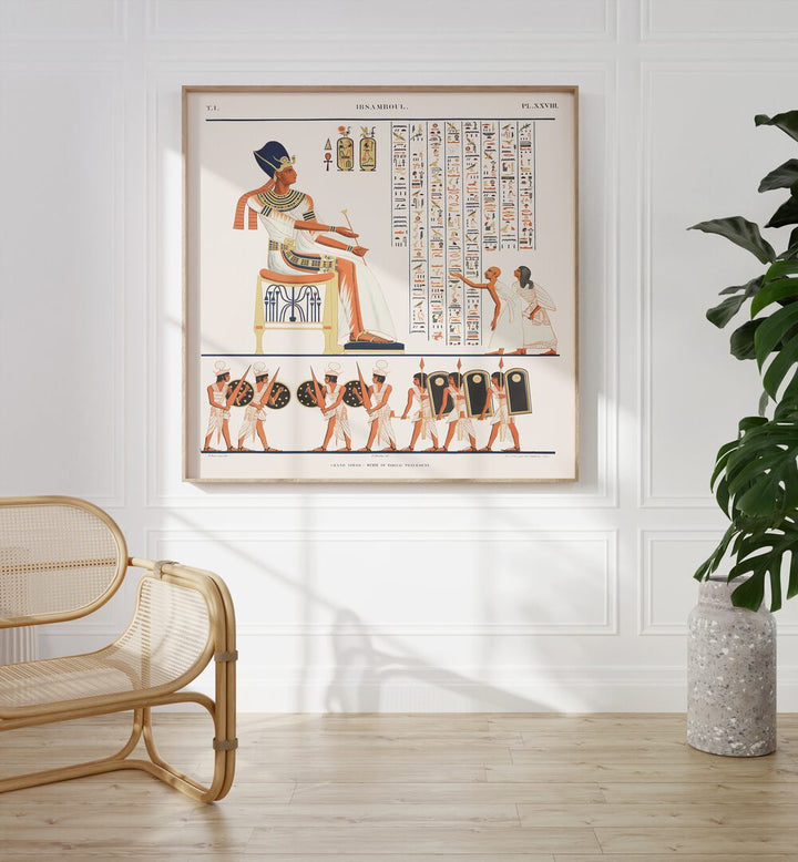 Great Speos North Wall Artwork Egyptian Cultural Art Painting Artwork in plain oakwood frame on white wall behind a chair