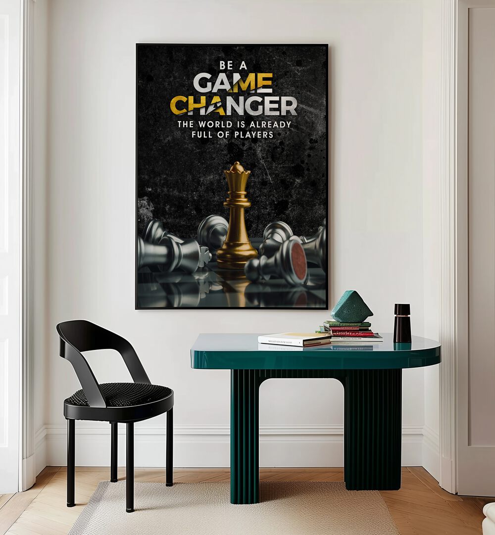 Game Changer Quotes And Typography Posters in Black Plain Frame placed on a Cream Colored Wall near a Study Table in a Workspace in the Drawing Room