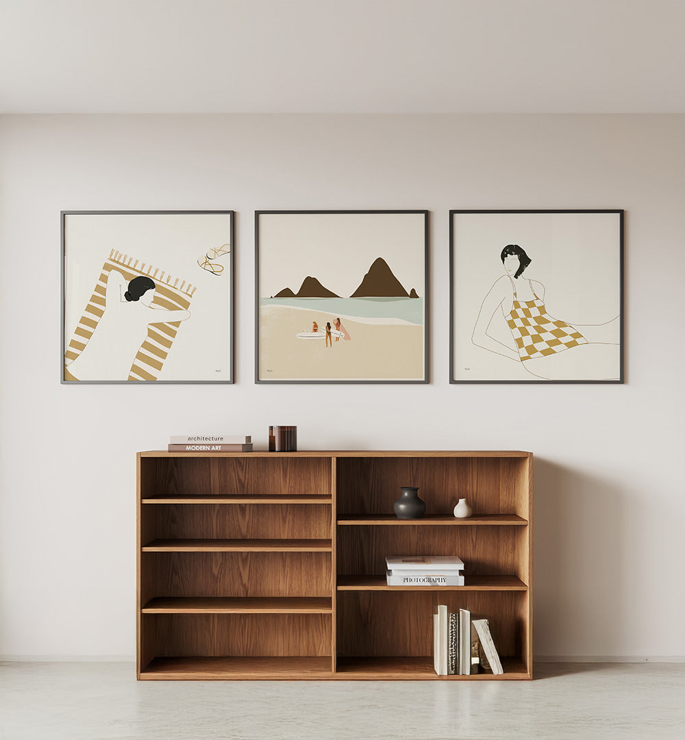 Wooden bookshelf with decorative items against a wall with framed artworks.