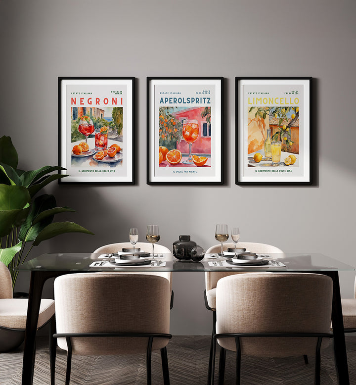Three framed posters on a wall above a dining table with chairs.
