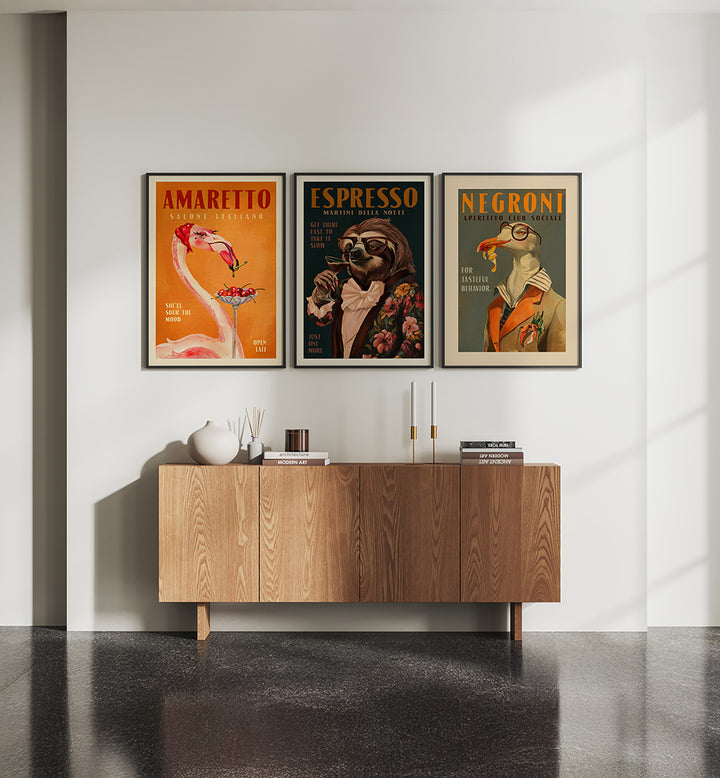 Three framed posters on a wall above a wooden cabinet.