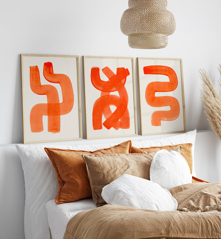 Decorative pillows on a sofa with abstract orange art in the background