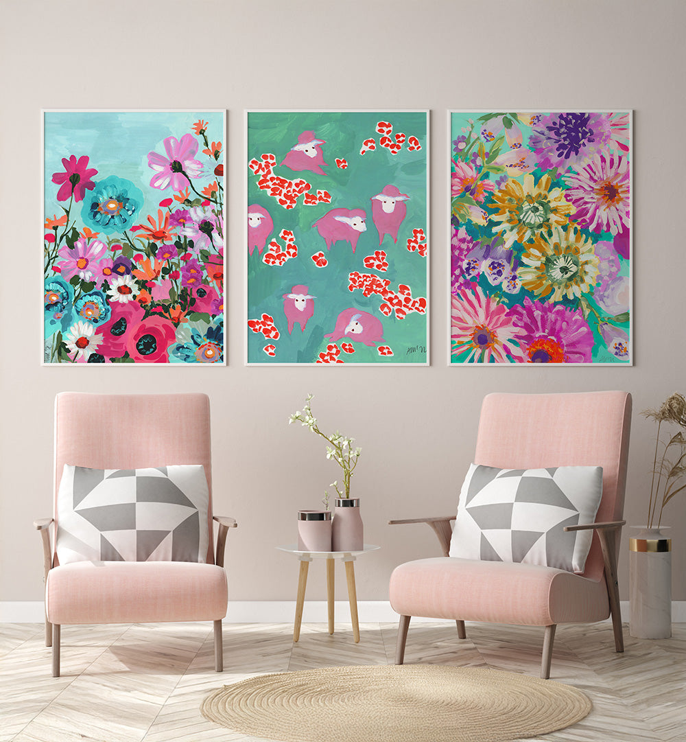 Three colorful floral paintings above two pink chairs with geometric cushions.
