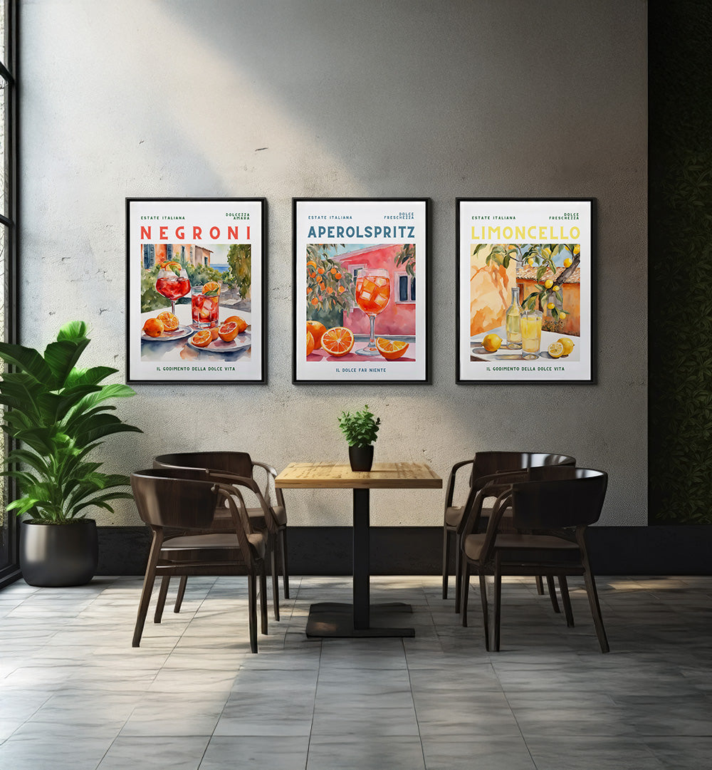 Modern cafe interior with tables, chairs, and wall art displaying Negroni, Aperol Spritz, and Limoncello cocktails.