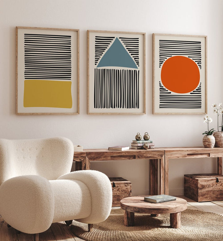 Geo Lines Set Set Of 3 Paintings in Oak Wood Plain Frame placed on a wall behind a table