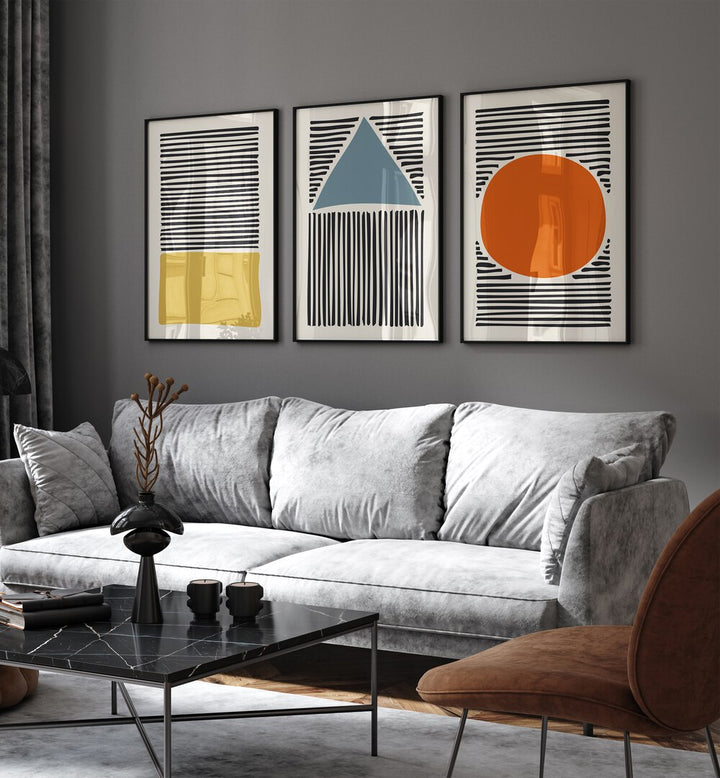 Geo Lines Set Set Of 3 Paintings in Black Plain Frame placed on a living room wall behind a sofa