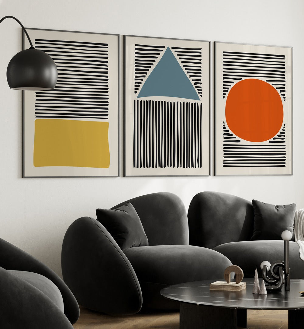 Geo Lines Set Set Of 3 Paintings in Black Plain Frame placed on a living room wall behind a sofa