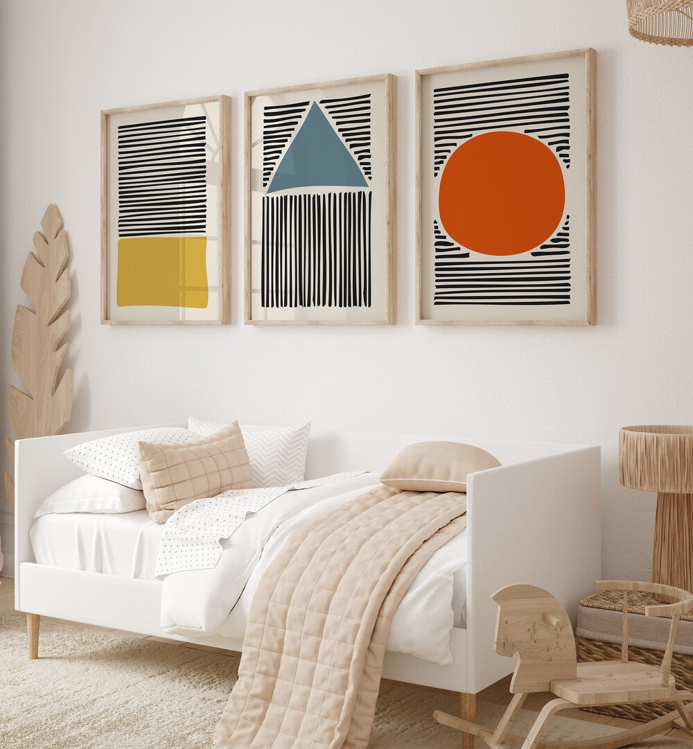 Geo Lines Set Set Of 3 Paintings in Oak Wood Plain Frame placed on a living room wall behind a sofa