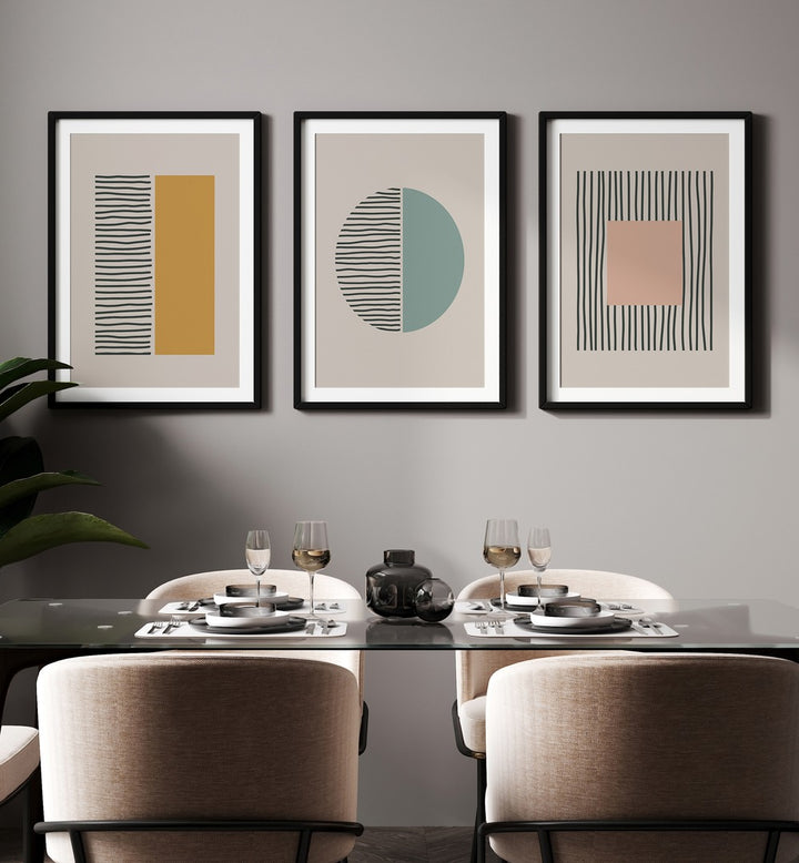 Geometric Duality Set Set Of 3 Paintings in Black Frame With Mount placed on a wall behind a dining table 