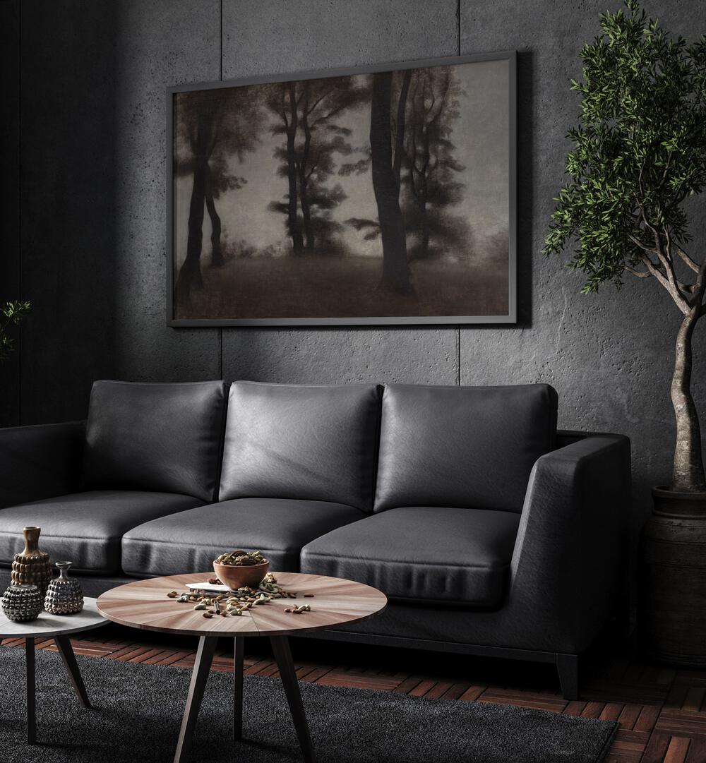 Gloomed Glade Gothic Wall Art Prints in Black Plain Frame hanging on a wall above black leather couch beside a plant.