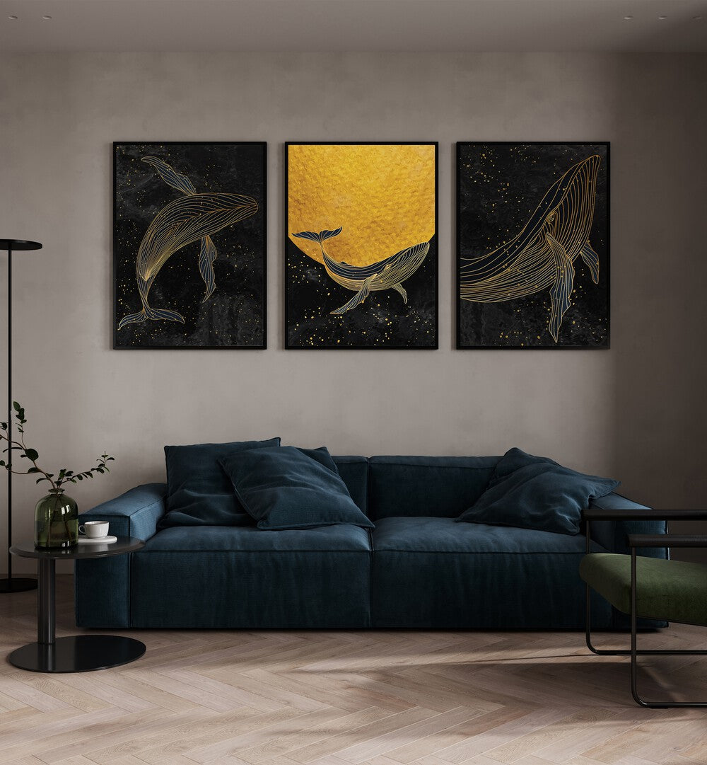 Golden Marina Set Of 3 Paintings in Black Plain Frame placed on a wall behind a blue sofa