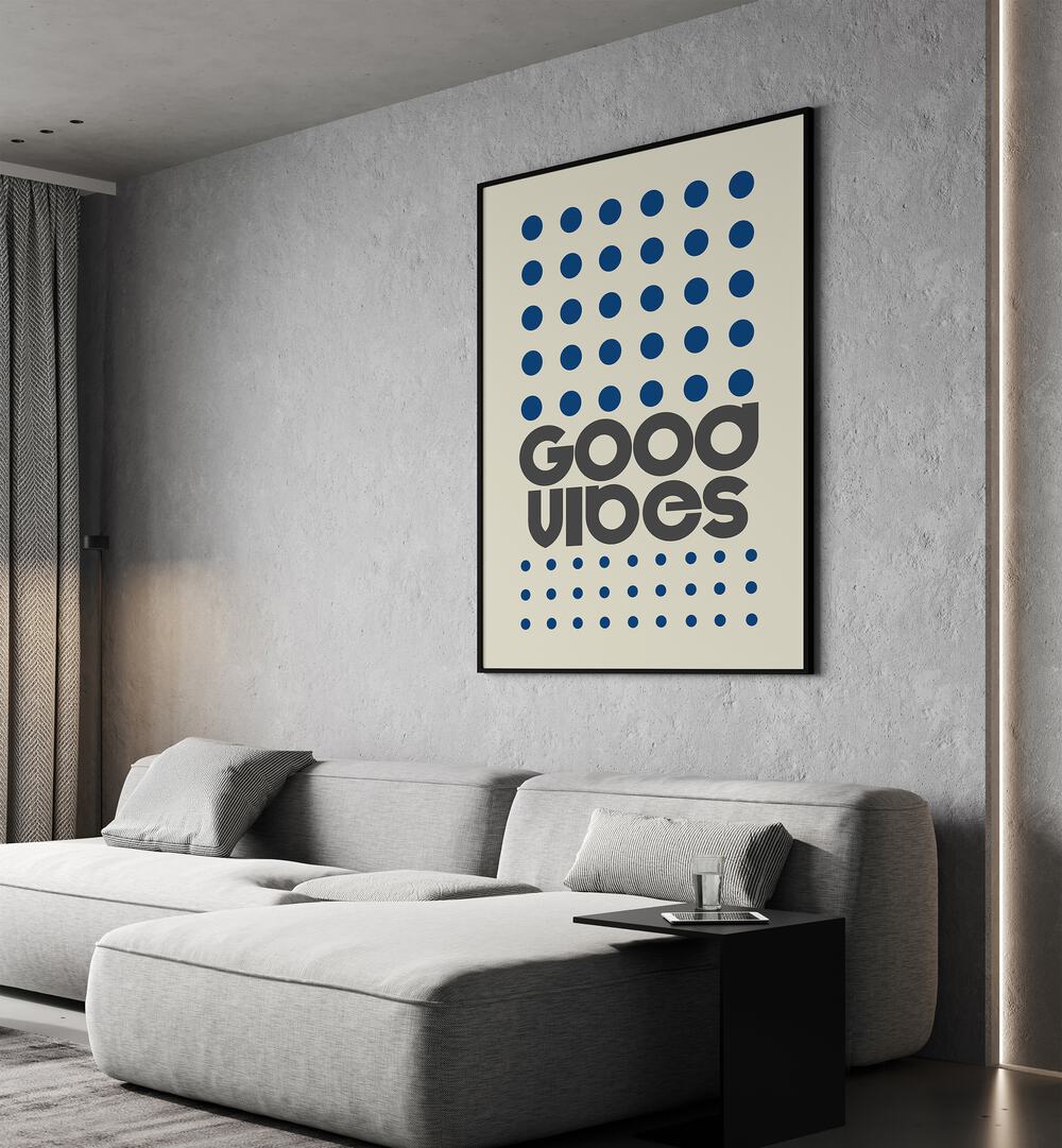 Good Vibes Quotes and Typography Posters in Black Plain Frame placed on a wall behind a sofa